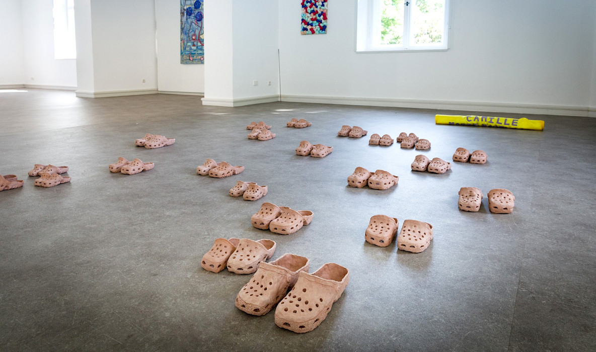 Camille Tsvetoukhine: Clogs (= french Sabots), 2024-25, 24 pairs of shoes, burnt red sandstone, Variable dimensions (Photo: Clemens Mayer)