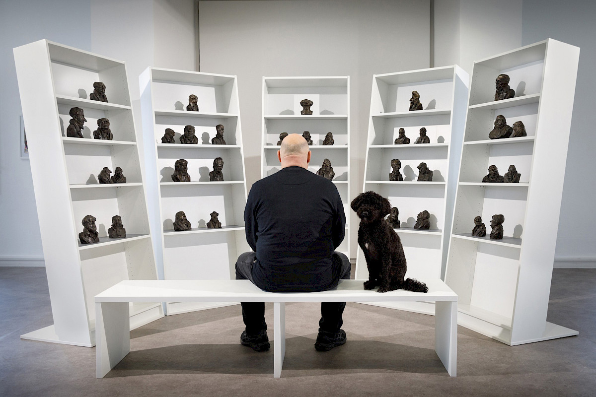 The artist Tom Biber in the exhibition “Die Perlenkette der Eliten” (© Clemens Mayer)